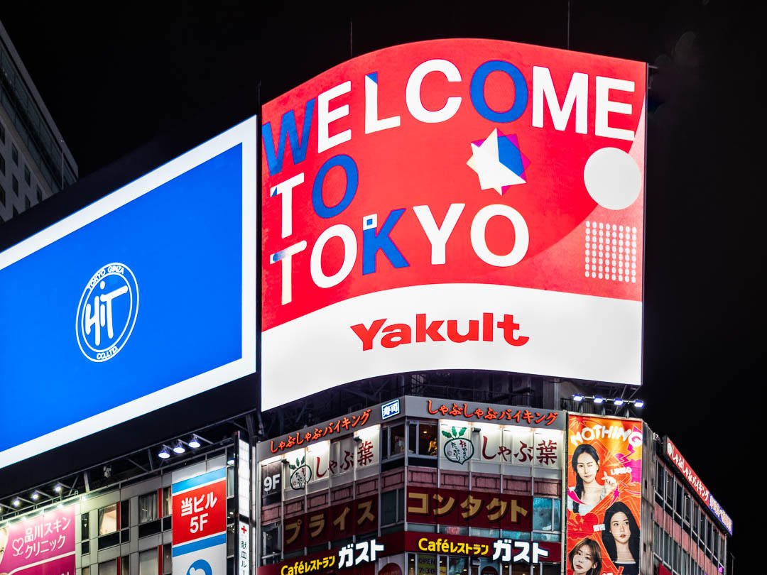 A "Welcome to Tokyo" billboard lit up at night in Shibuya